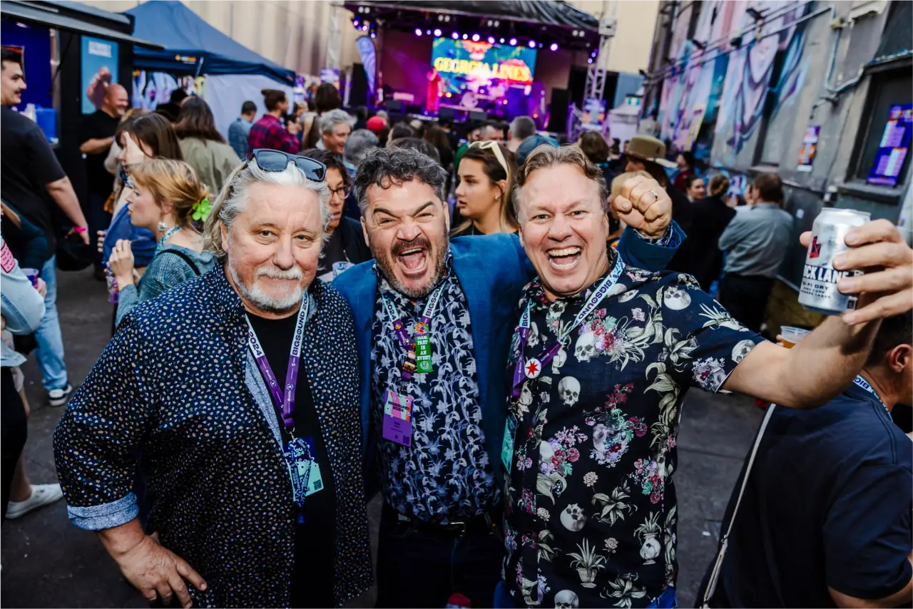 Three partners smiling together at a laneway event