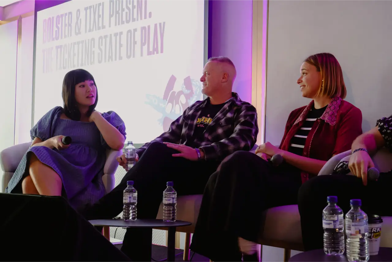 A panel of four speakers on stage at an industry talk