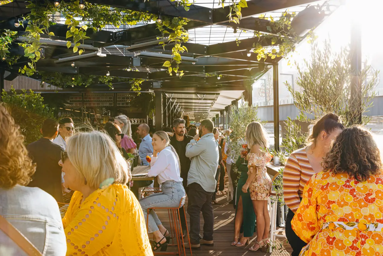 A leafy beer garden full of people in the afternoon sun